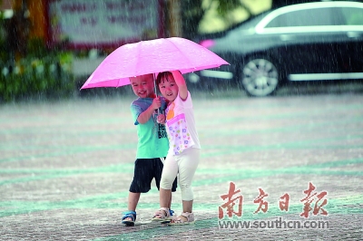 26日,深圳街头两名小朋友在雨中撑伞行走.全媒体记者 朱洪波 摄